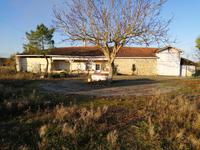 A la campagne, ferme en pierre avec dépendances et puits.